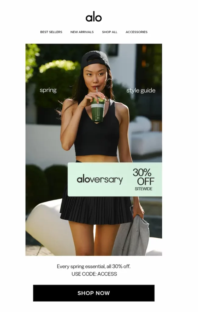 Alo Yoga spring campaign image with a woman in a black crop top and pleated mini skirt sipping a green smoothie outdoors. Overlaid text reads “Aloversary – 30% Off Sitewide.”