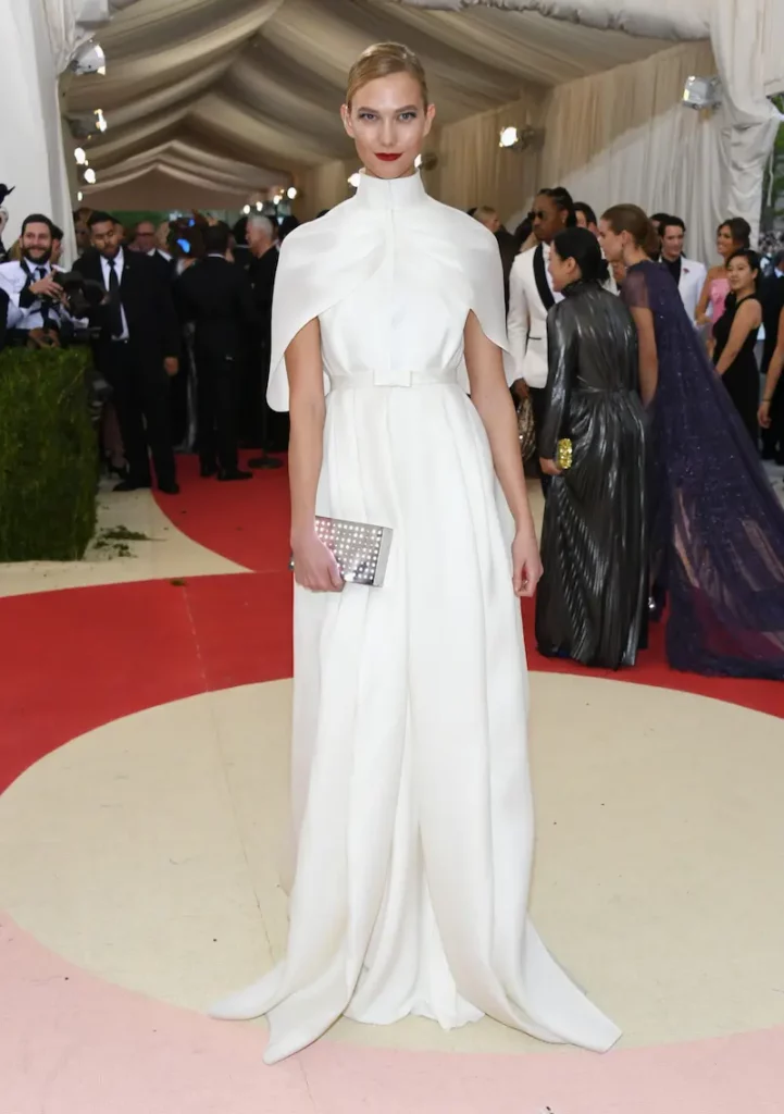 woman in an elegent high-neck white gown on the red carpet by Vogue
